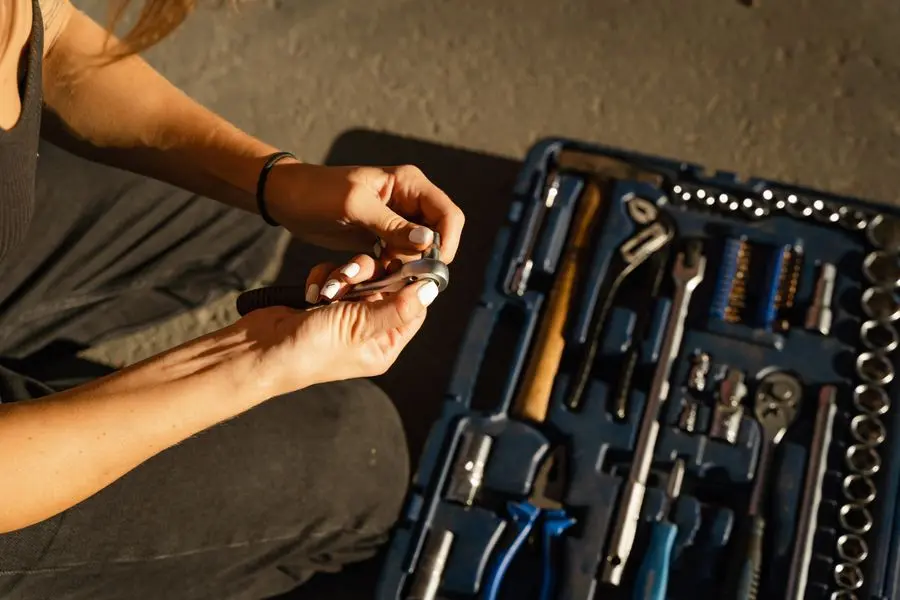 Mains choisissant un outil dans une caisse à outils