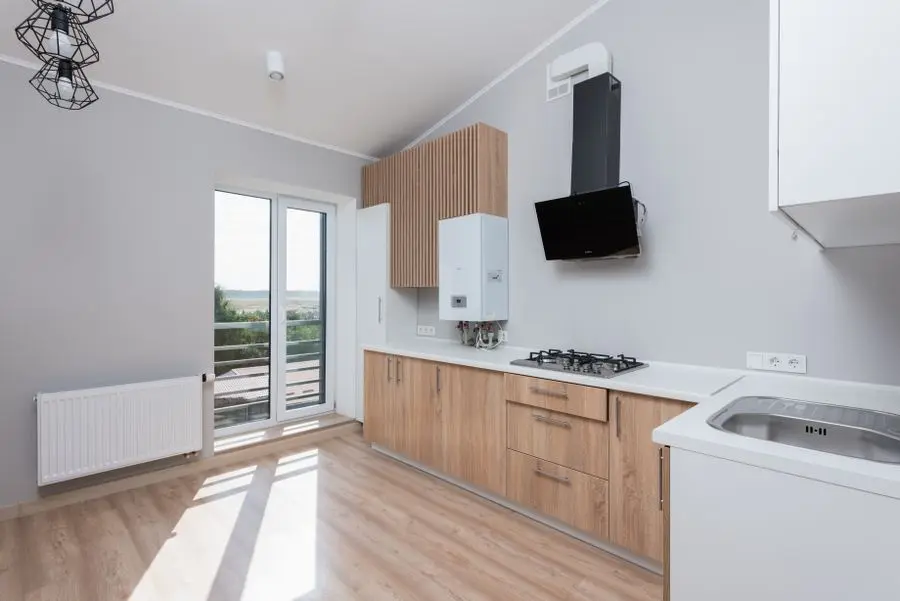 Cuisine équipée d'une chaudière murale et d'un radiateur