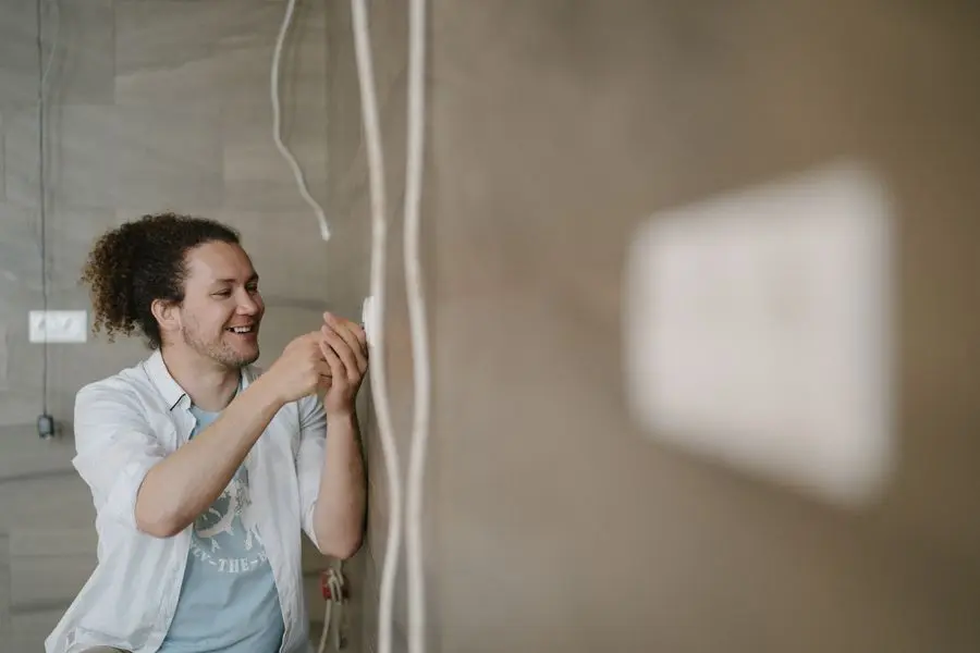 Électricien réglant une prise murale
