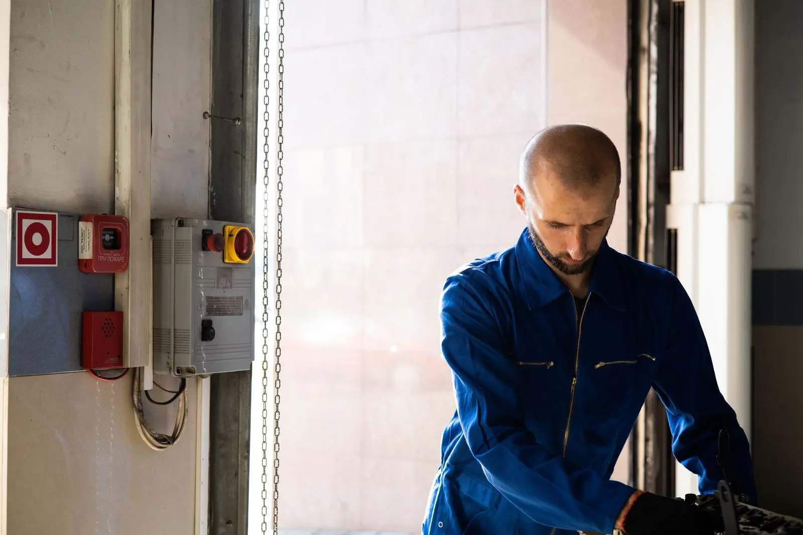 Électricien en tenue de travail devant une armoire électrique