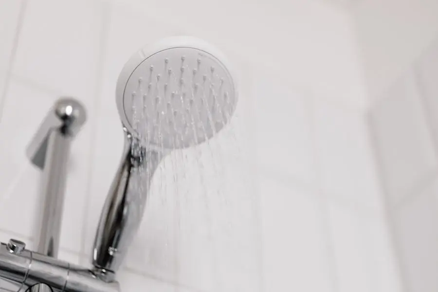 Pommeau de douche sur fond de carrelage blanc