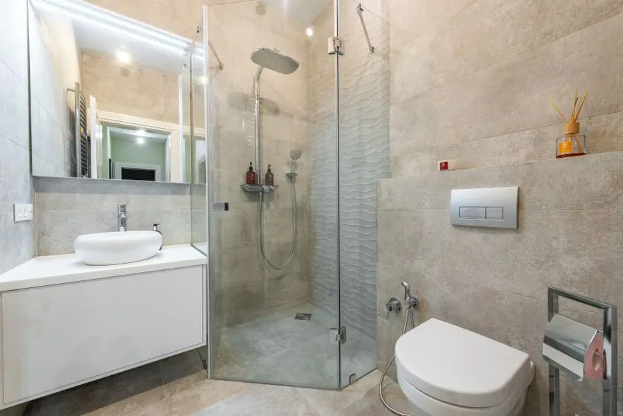 Salle de bain rénovée avec douche vitrée, lavabo et WC suspendu