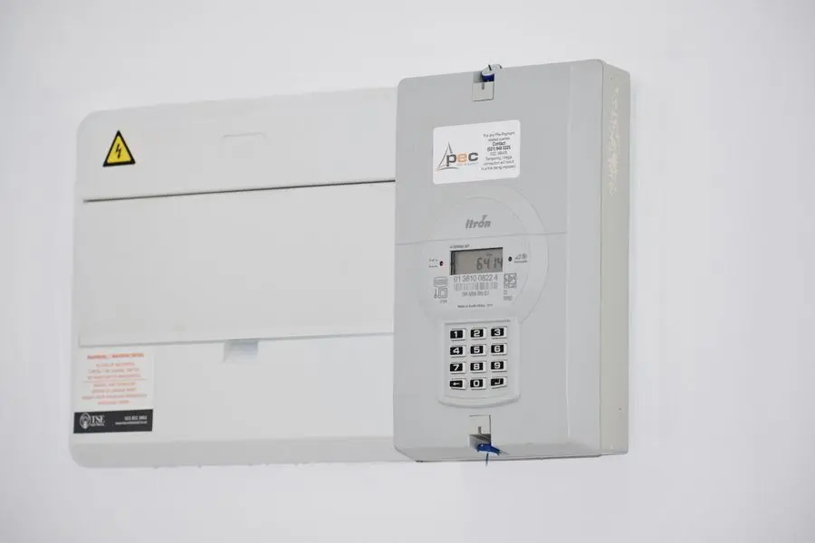 Tableau électrique fixé sur un mur blanc
